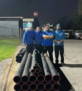 A group Madden employees standing in front of a stack of flexible piping