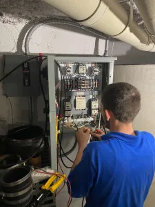 A Madden employee working at an electrical panel