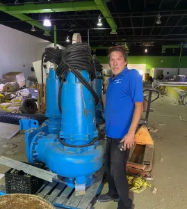 A Madden employee standing in front of a piece of plumbing equipment